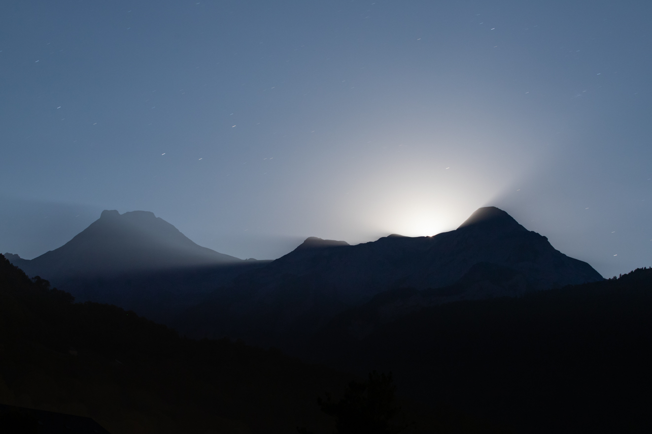 The moon breaks over the mountains above Laruns, in the French Pyrenees.